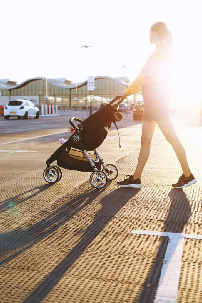 Une maman pousse un poussette landau