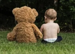 un bébé parle avec un ours en peluche