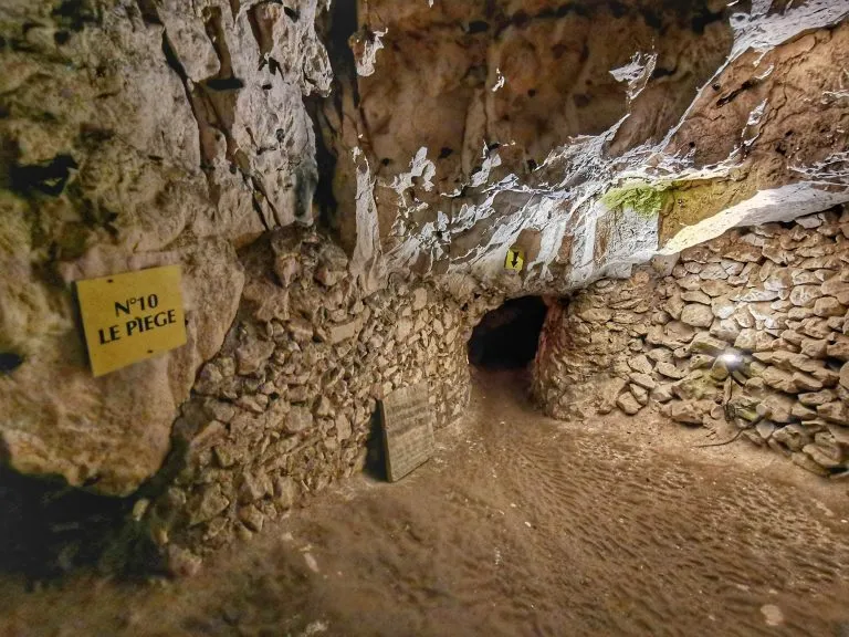 Caverne avec panneau et tunnel sombre