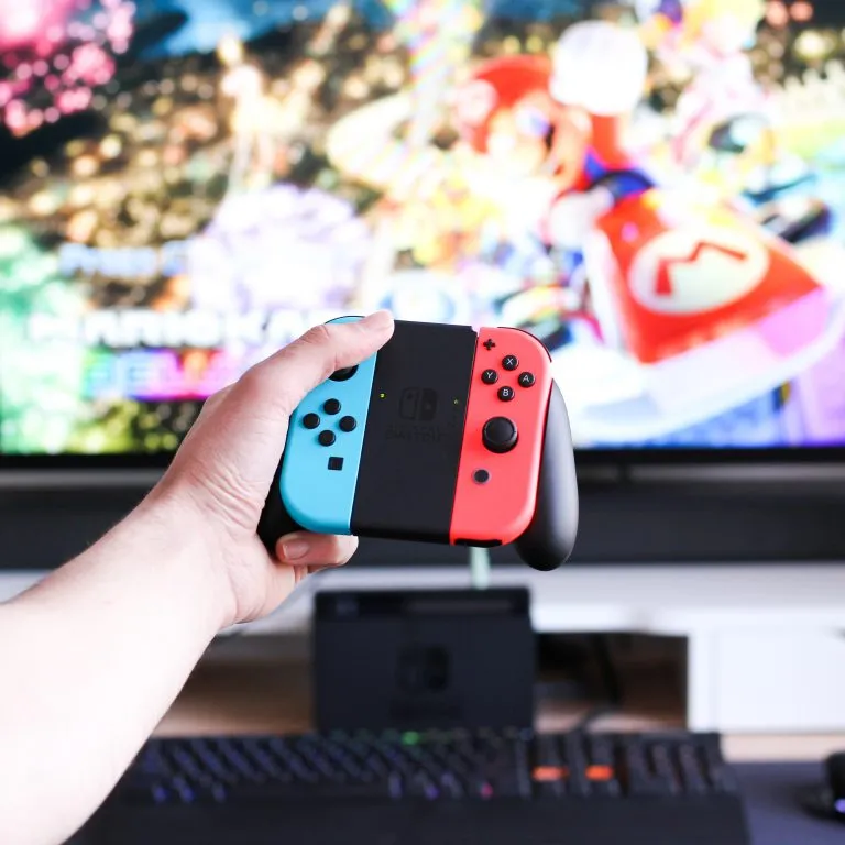 La Nintendo Switch et la manette devant la télé