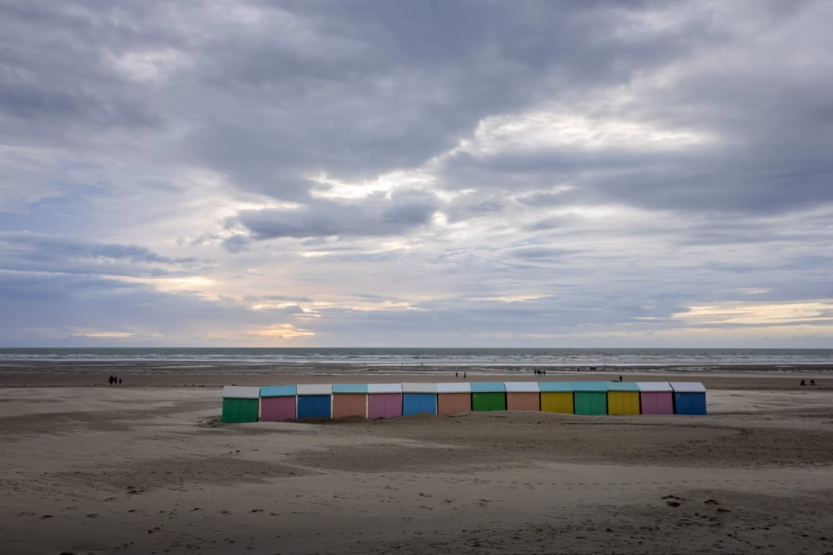 Cabines colorées sur la plage déserte.