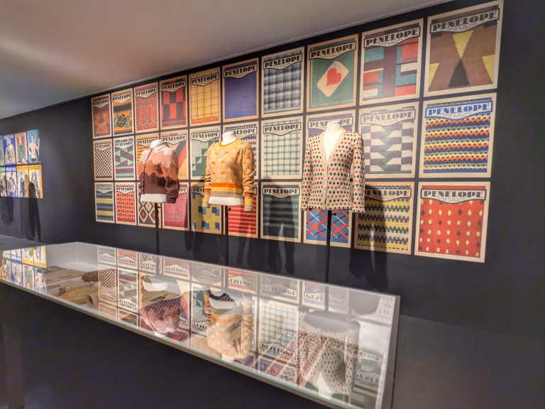 Vêtements colorés exposés sur mur poue l'exposition La redoute